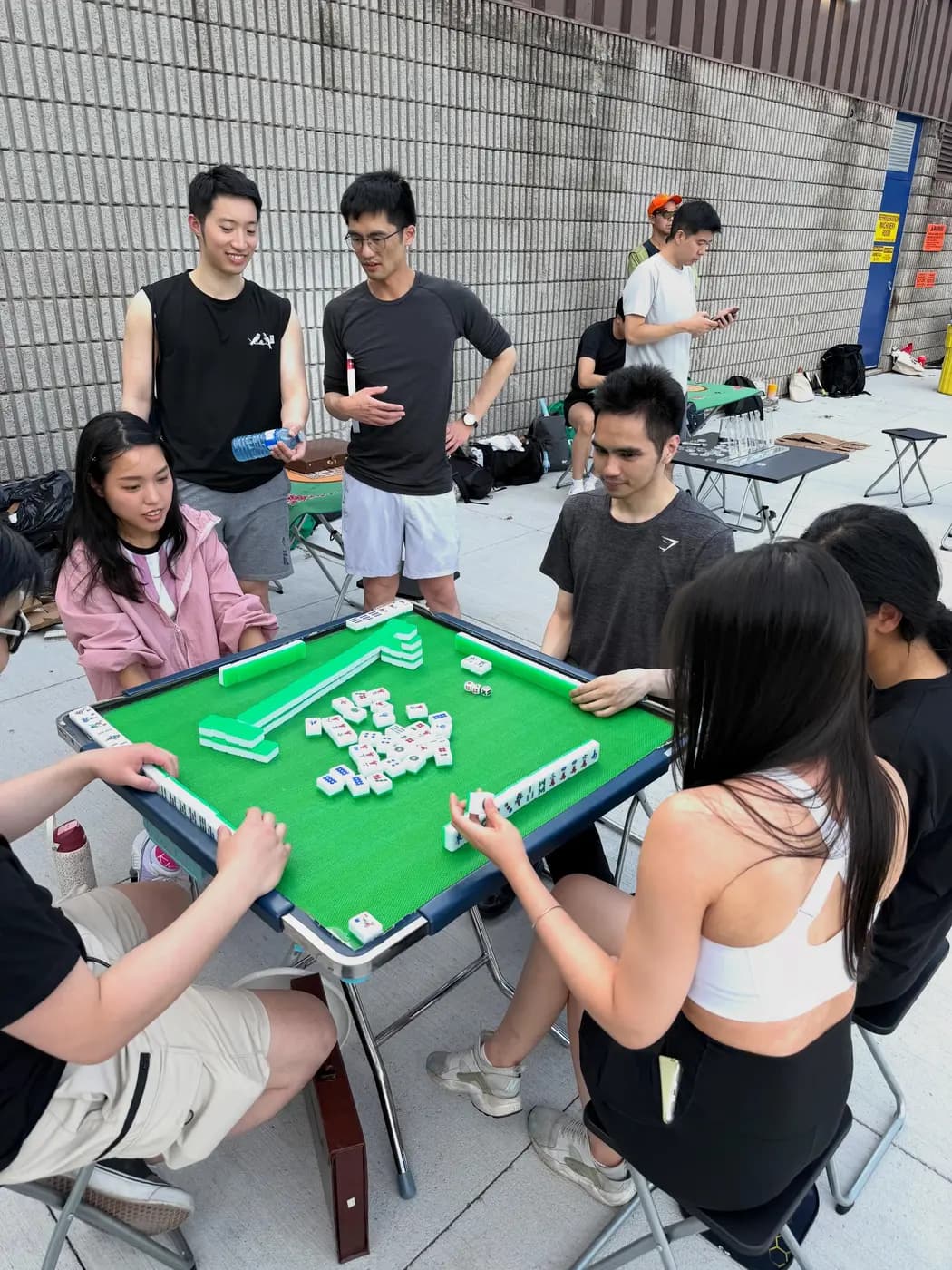 Members playing mahjong between games at a social